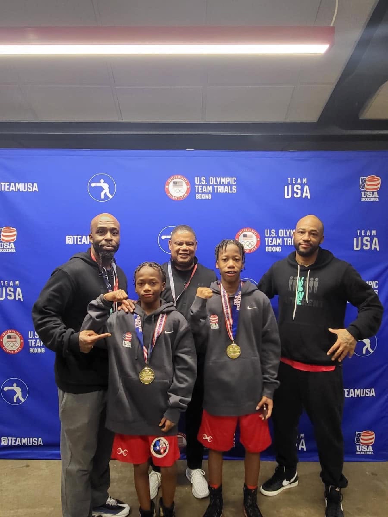 AM Pro Charities coaches with two young athletes wearing medals at the U.S. Olympic Team Trials for Boxing